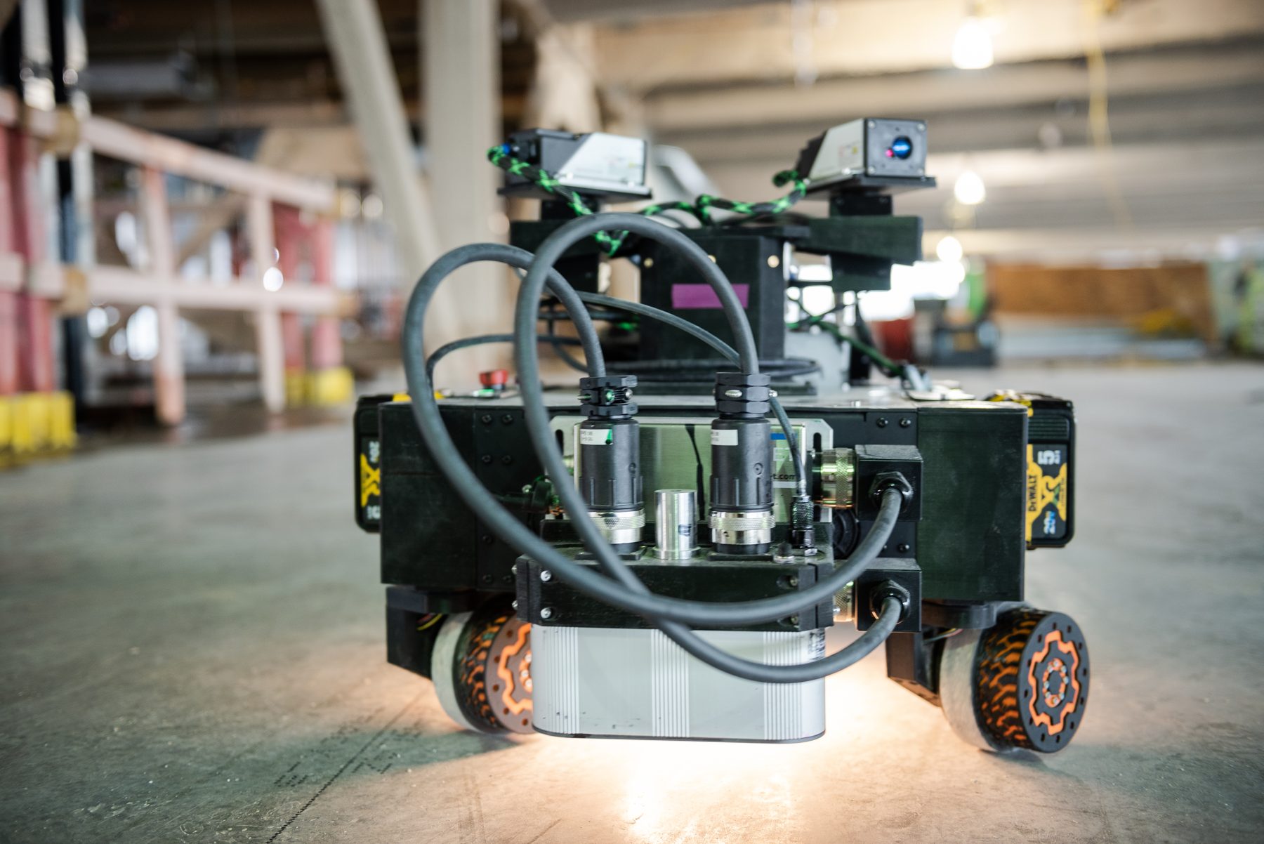 Early Rugged Robotics layout robot with an exposed sheet-metal chassis, mecanum wheels, and sensors
